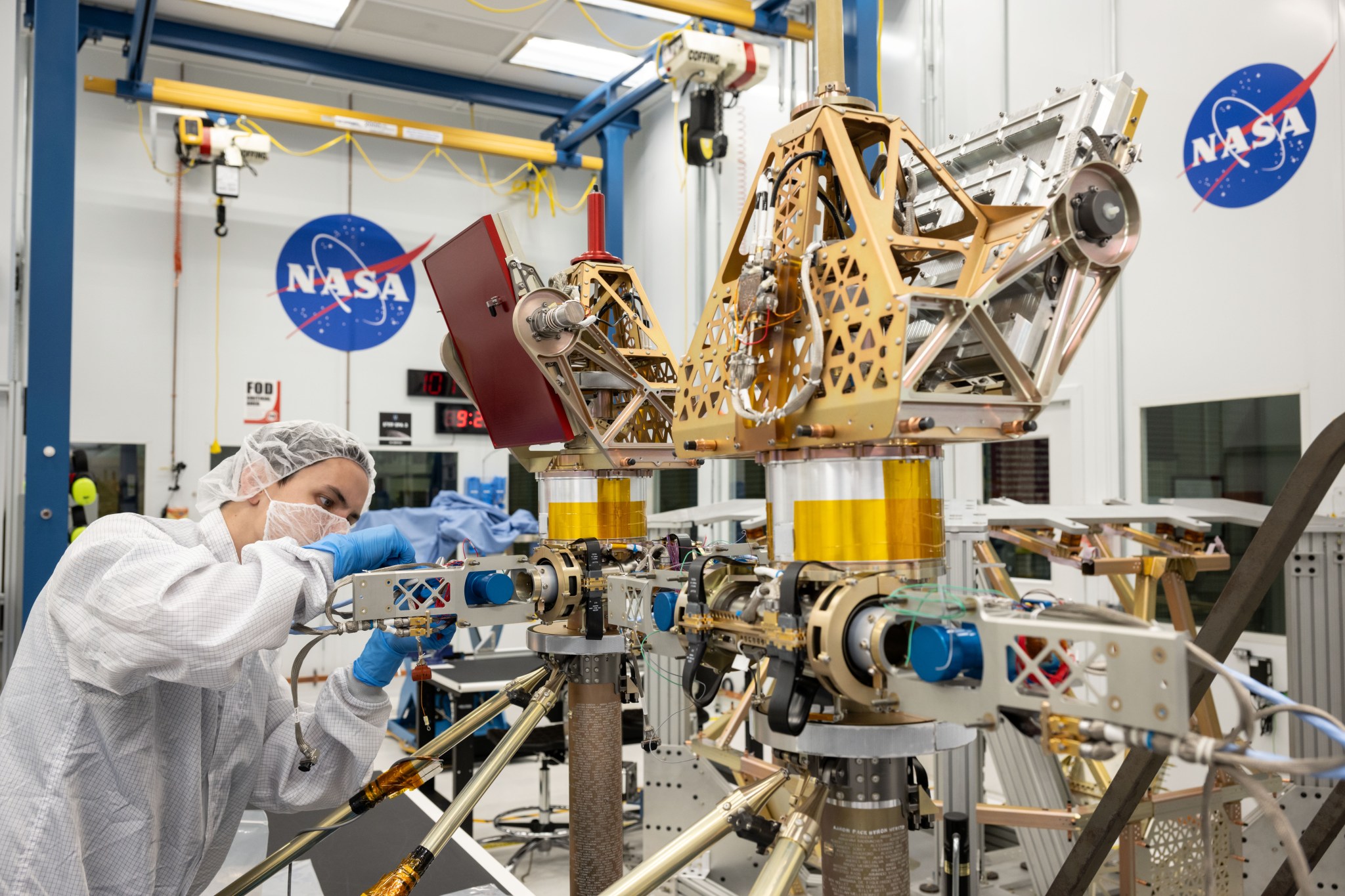 Engineers in white suits assemble and test NASA's first robotic Moon rover in a clean room at NASA's Johnson Space Center in Houston.