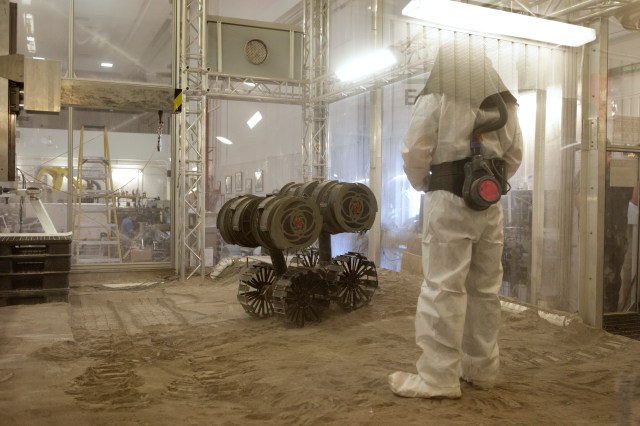 A robotics engineer makes adjustments to the Regolith Advanced Surface Systems Operations Robot (RASSOR) during testing in the regolith bin inside Swamp Works at NASA’s Kennedy Space Center in Florida.