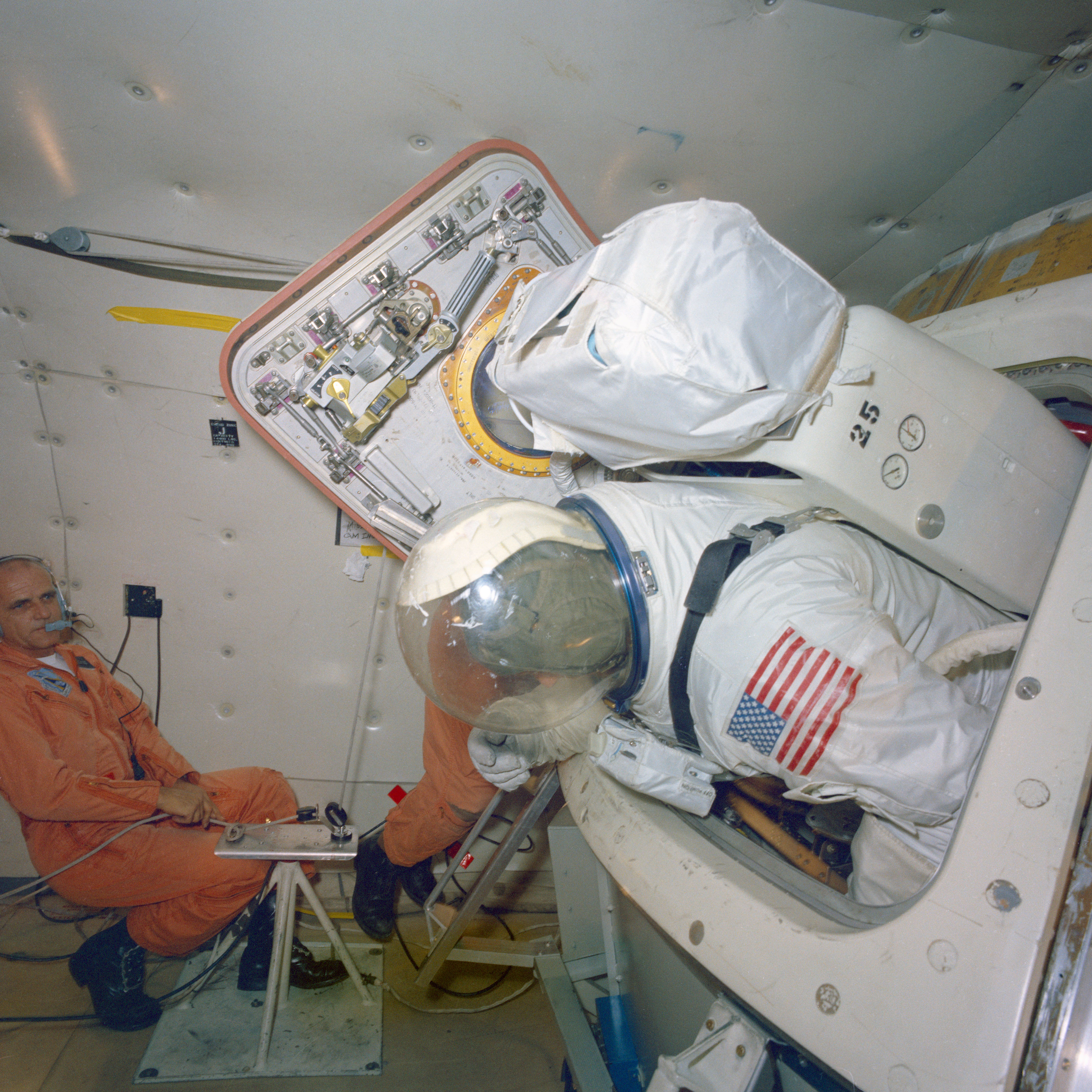 Apollo 9 astronaut Russell L. Schweickart practices entering and leaving the Command Module while wearing a pressure suit during brief periods of weightlessness aboard a KC-135 aircraft