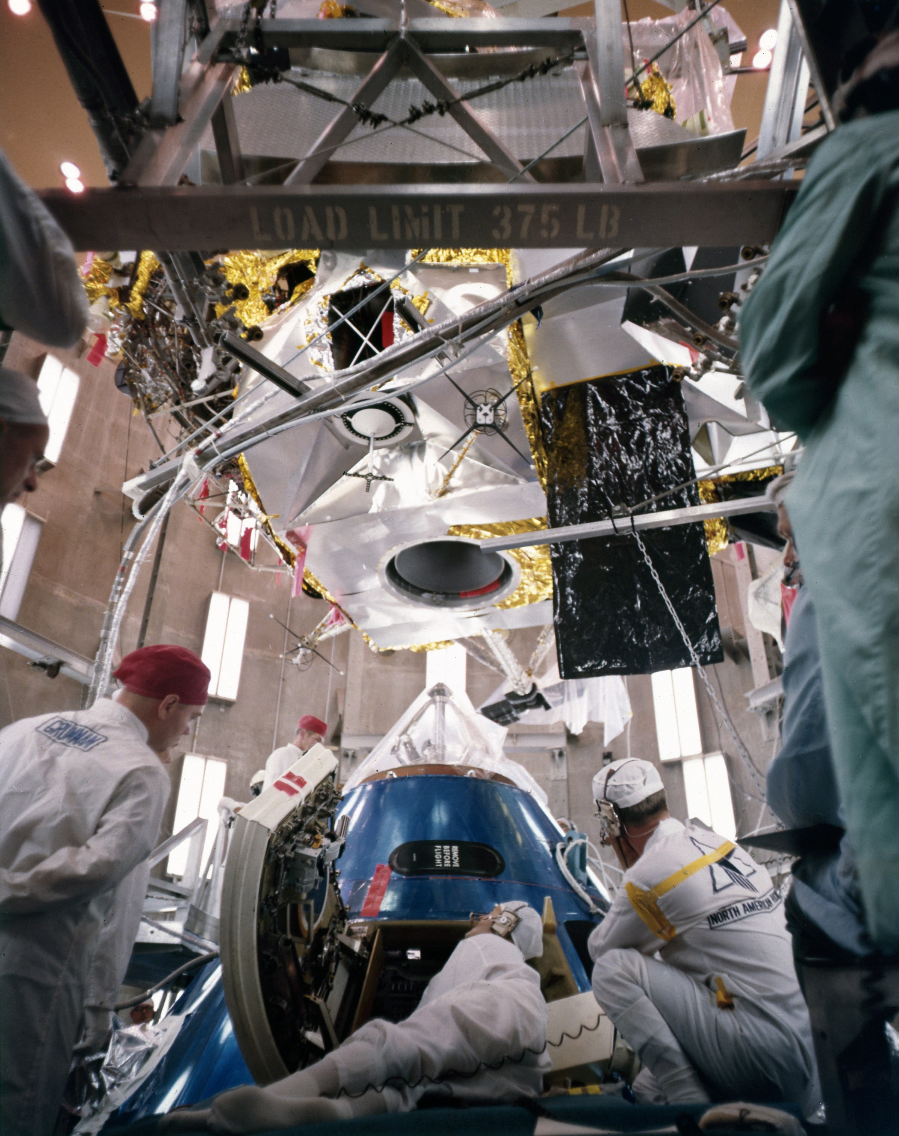 Engineers conduct a docking test between the Apollo 9 CM, bottom, and Lunar Module in an altitude chamber in KSC’s Manned Spacecraft Operations Building
