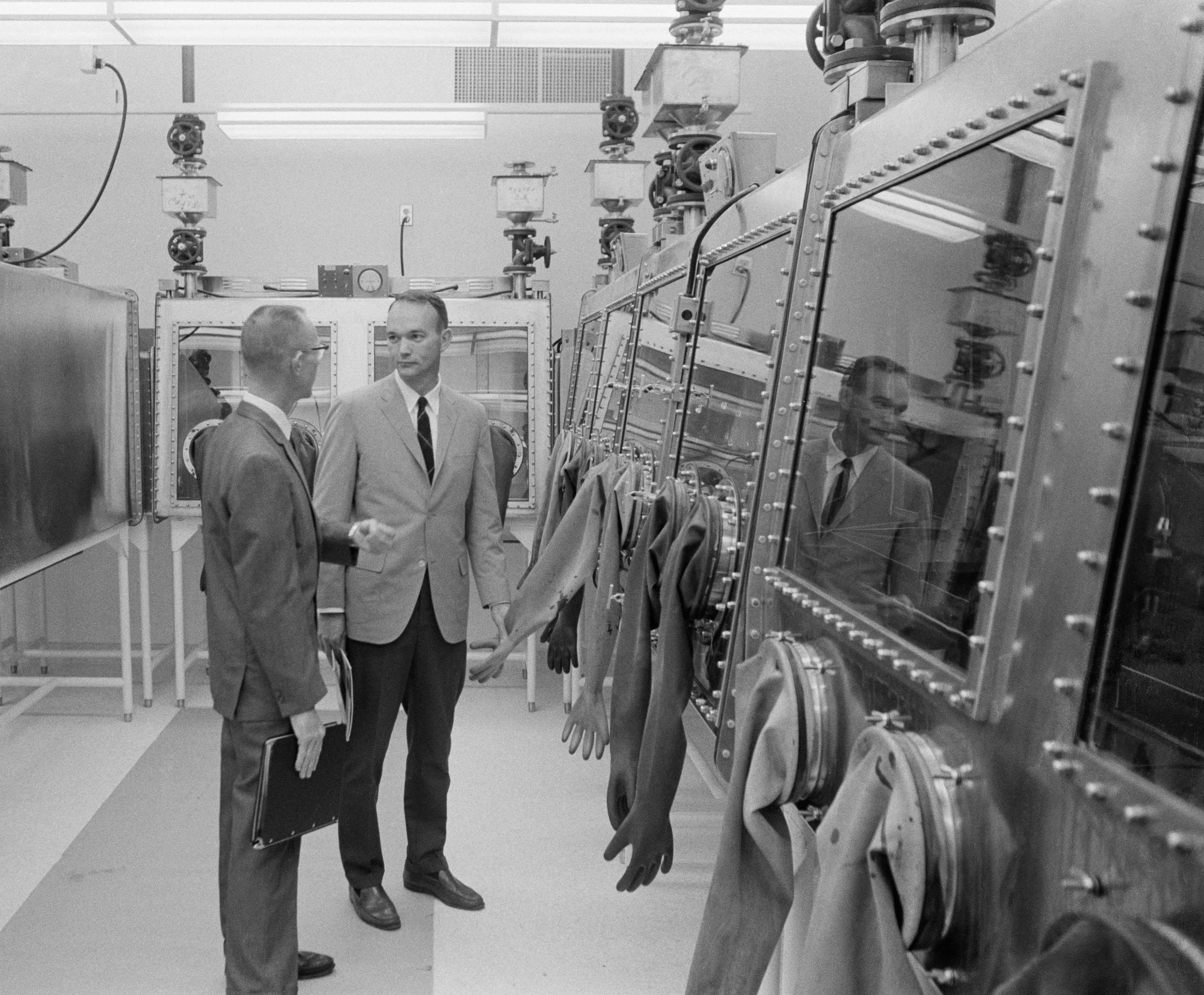 Richard Wright, administrative assistant for the Lunar Receiving Laboratory, gives astronaut Michael Collins a tour of the gloveboxes for examining lunar samples