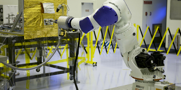 An industrial robot at Kennedy Space Center tests propellant transfer technologies during RROxiTT