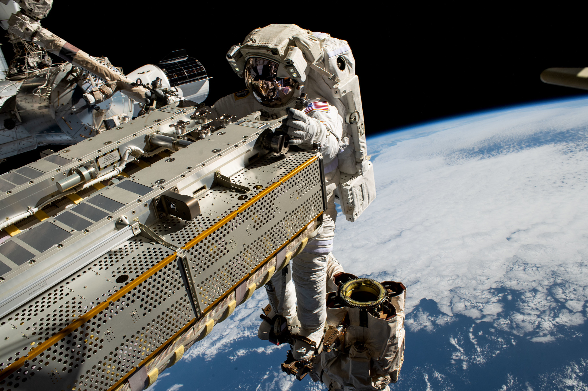 NASA astronaut and Expedition 68 Flight Engineer Woody Hoburg rides the Canadarm2 robotic arm while maneuvering a roll-out solar array toward the International Space Station's truss structure 257 miles above the Pacific Ocean.