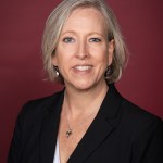 white female in black suit and white shirt