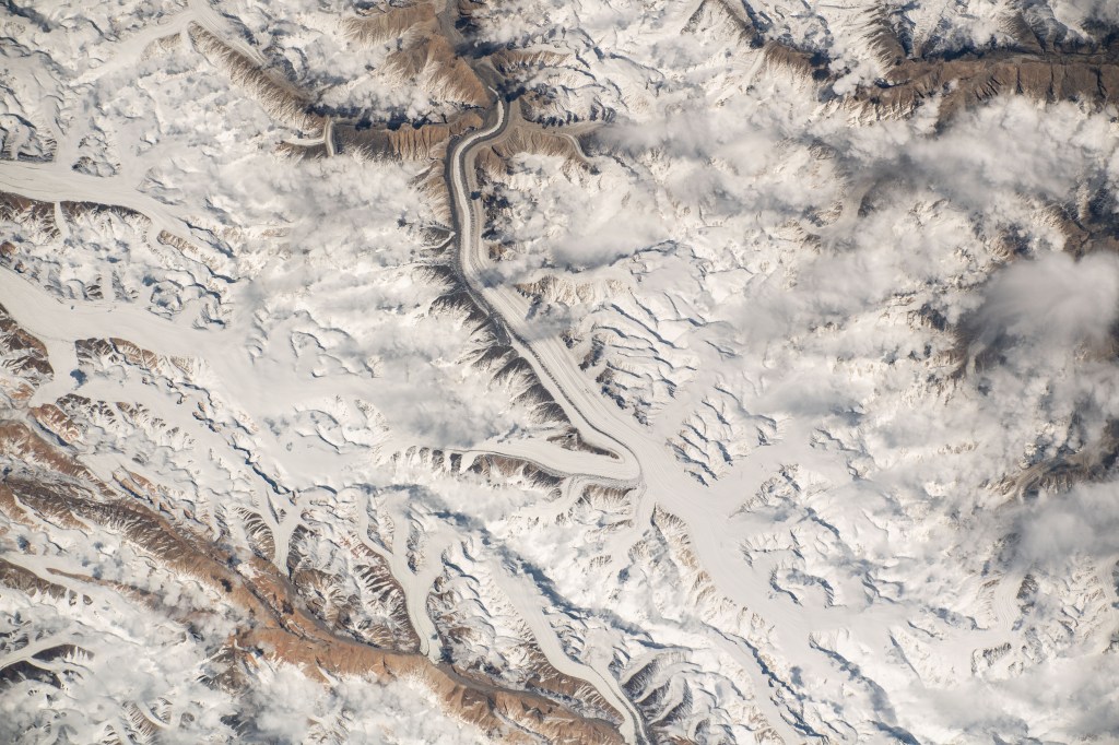 iss070e006424 (Oct. 19, 2023) -- Snow drifts and scattered clouds blend together in the Karakoram mountain range. Spanning the borders of Pakistan, India and China, the range is one of the world's most geological areas. The International Space Station soared 260 miles above India as this photograph was taken.