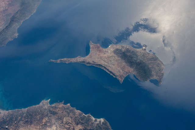iss070e008985 (Oct. 24, 2023) -- The Sun glistens on the waters of the Mediterranean Sea, surrounding Cyprus island. The highest point on the island, Mount Olympus, shadows the base of the mountain range as the International Space Station soared 260 miles above.