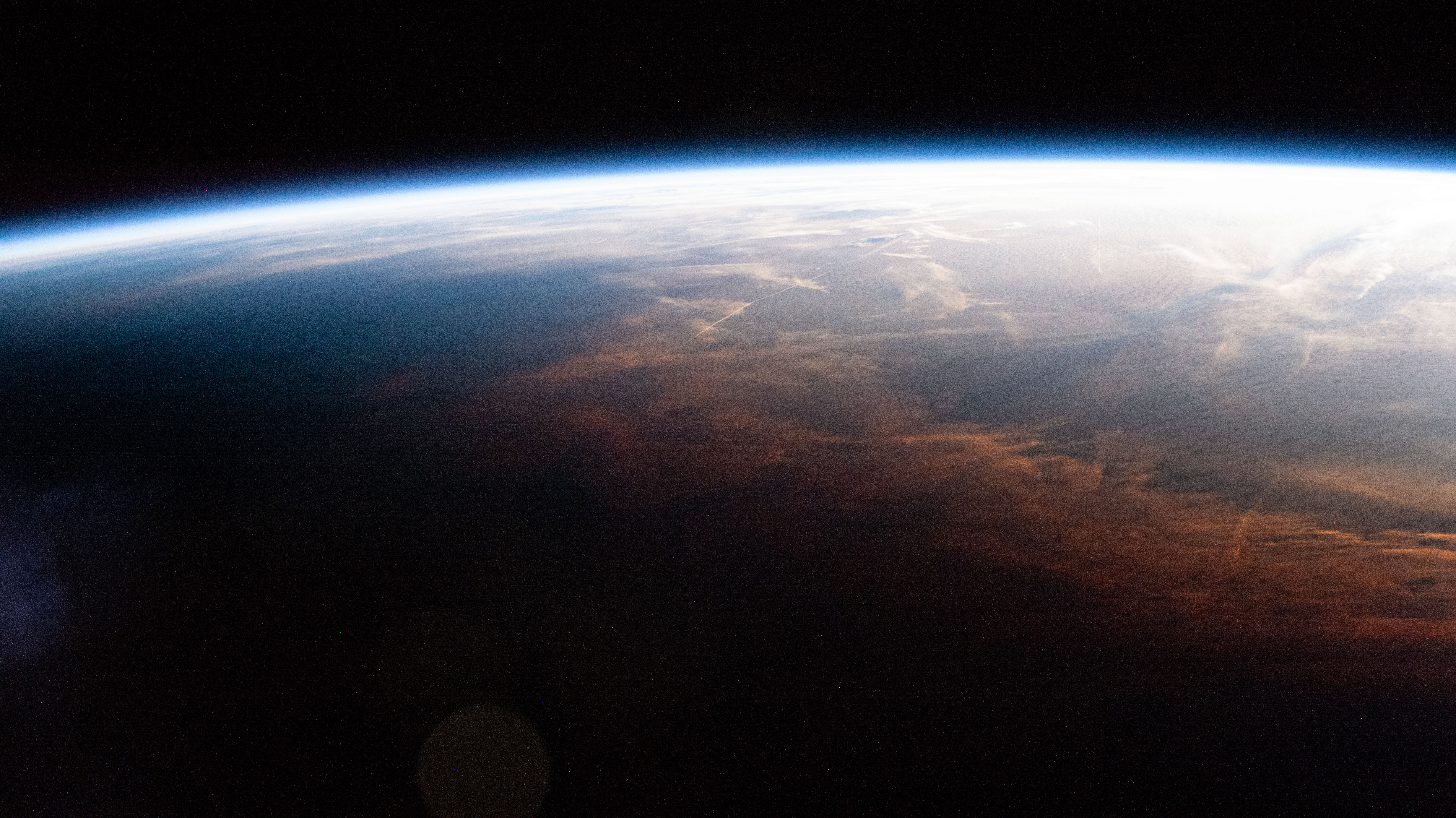 iss070e008937 (Oct. 25, 2023) -- As the International Space Station entered orbital nighttime 260 miles above the Southernmost Point of Alaska, shadows can be seen reaching a wall of clouds colored coral from the Sun.