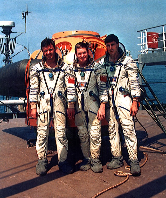The first crew of the International Space Station pose aboard a Black Sea freighter before beginning water survival training recently. From left, they are Soyuz Commander and Russian Cosmonaut Yuri Gidzenko; International Space Station Commander Bill Shepherd; and Flight Engineer and Russian Cosmonaut Sergei Krikalev. In the background is a mockup of the Russian Soyuz spacecraft descent module used in training. The crew is scheduled to be launched to the new station aboard a Soyuz spacecraft in January 1999.