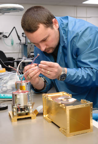 Aaron Schooley checks the quality of electrical connectors