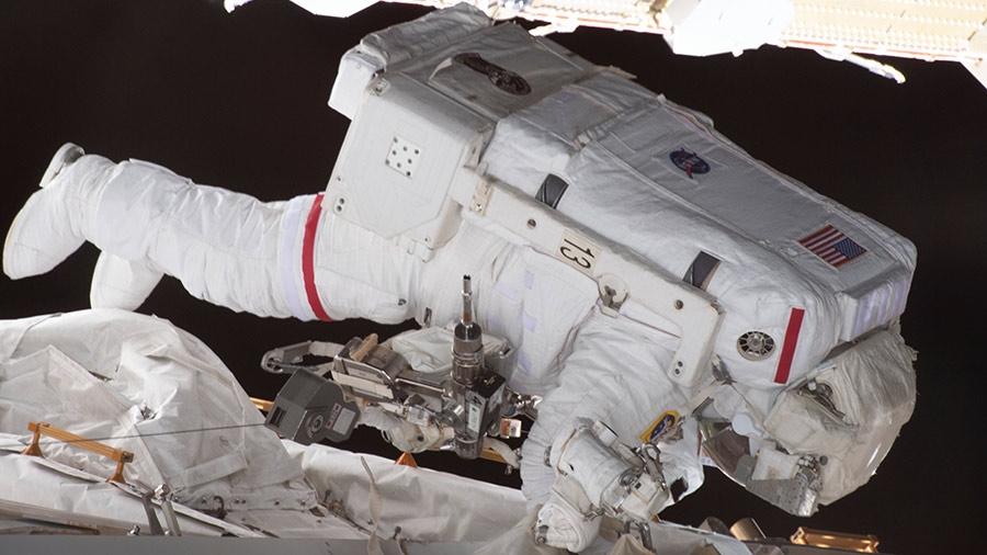 Astronaut Jasmin Moghbeli is pictured tethered to the space station during a spacewalk to replace solar array hardware.