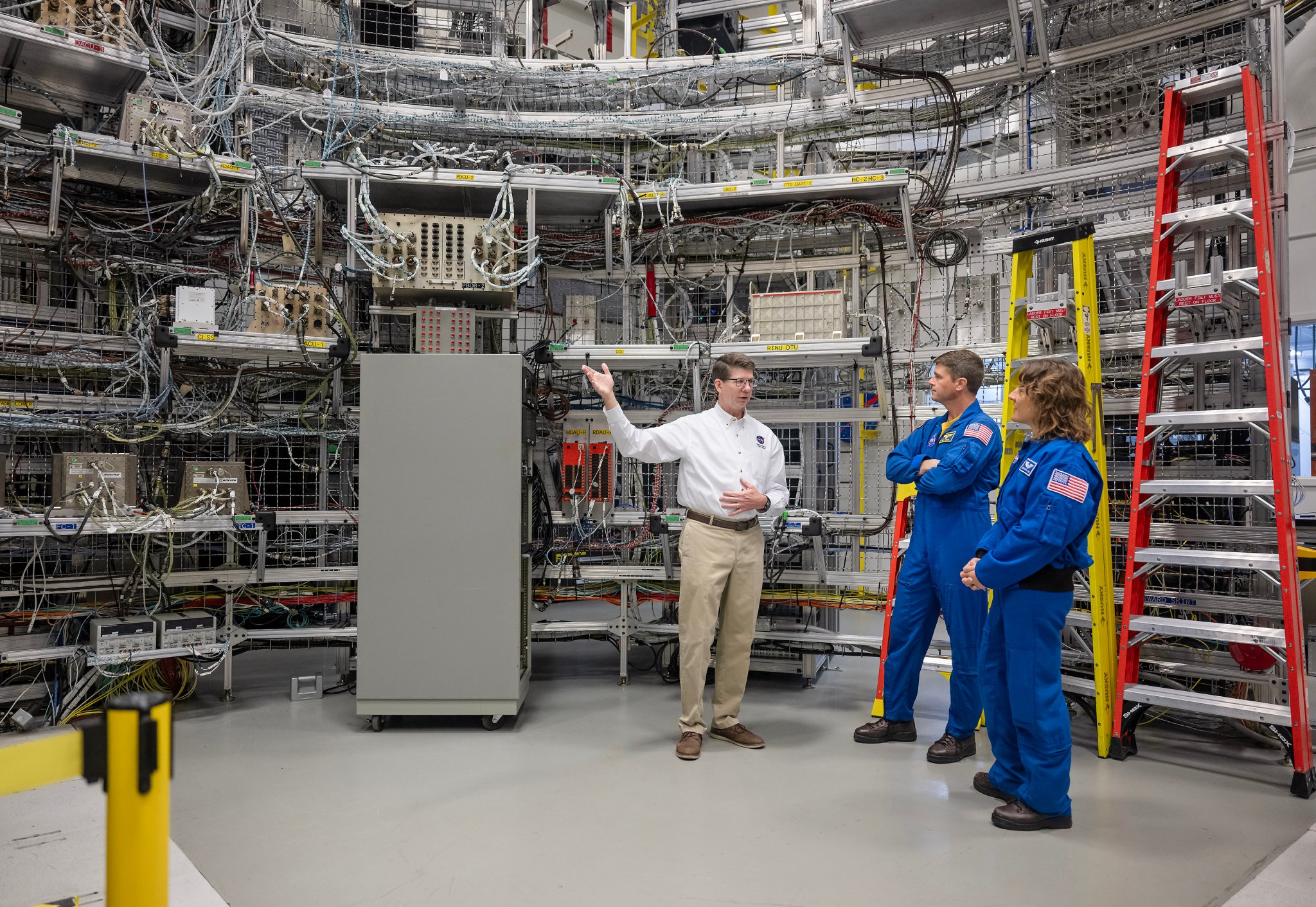 Dan Mitchell, lead SLS integrated avionics and software engineer, talks with Wiseman and Koch as they visit the Systems Integration Lab at Marshall.