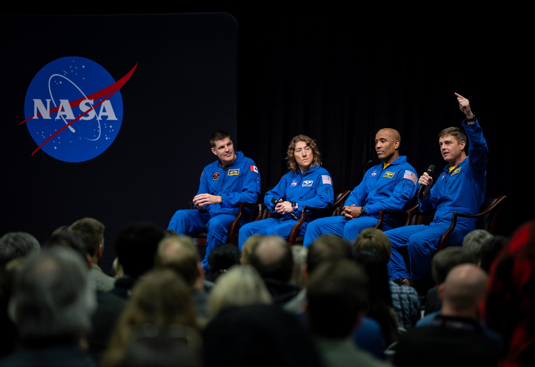 From left, Artemis II astronauts Jeremy Hansen, Christina Koch, and Victor Glover listen as Commander Reid Wiseman talks during an employee event at NASA’s Marshall Space Flight Center on Nov. 27.