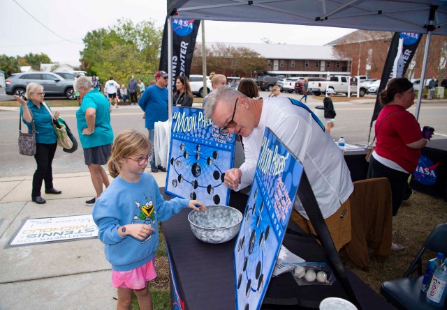 Young attendee learns about the phases of the moon at Stennis Day in the Bay