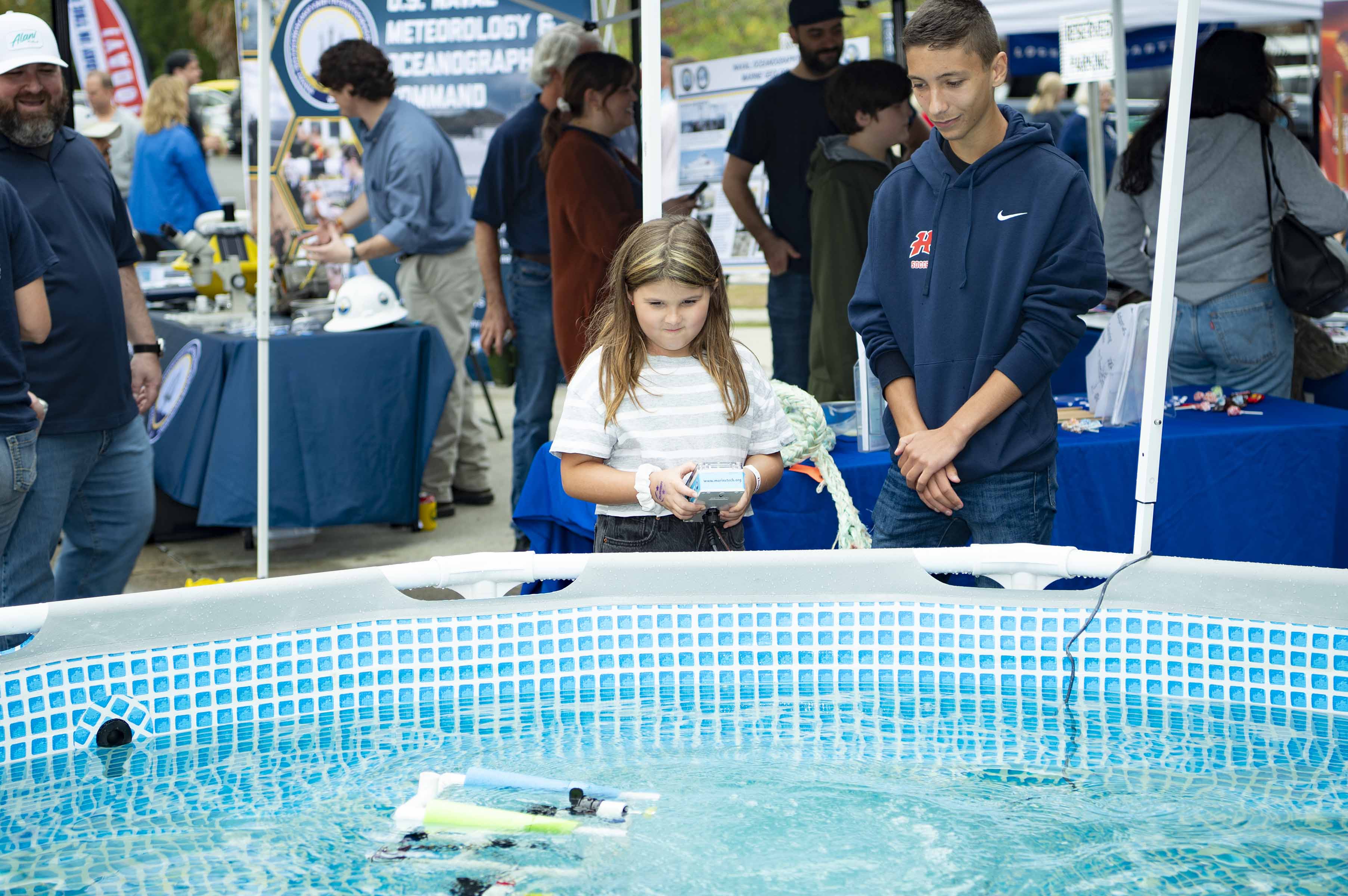 Students navigate robot underwater.