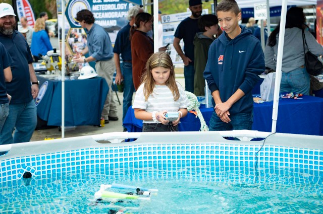 Students navigate robot underwater.