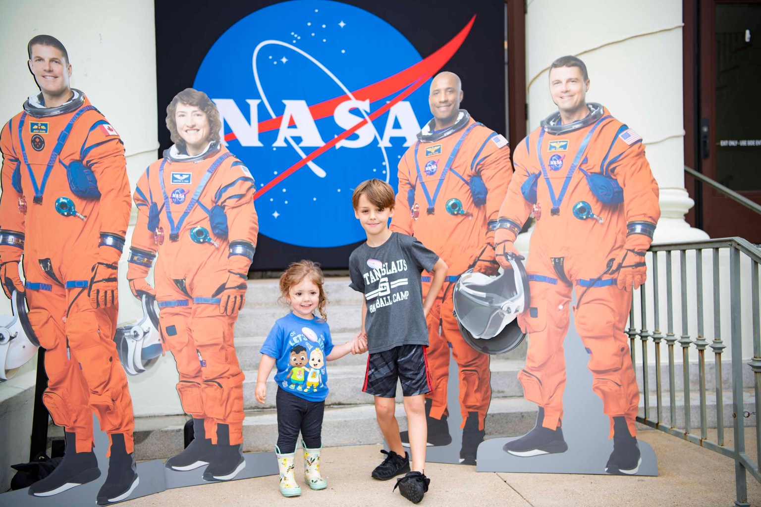 Young attendees pose with four astronaut standees at Stennis Day in the Bay