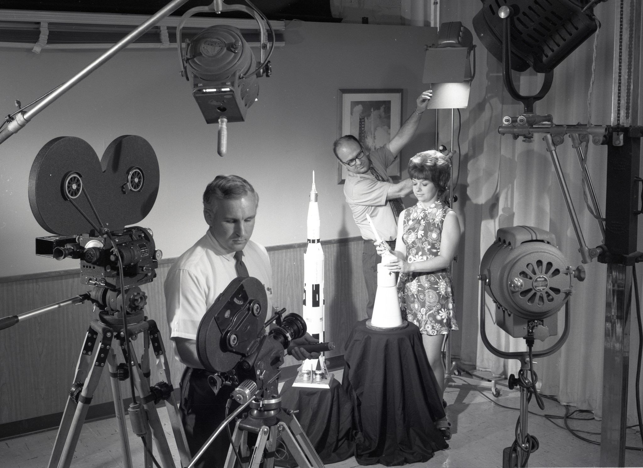 Three people in studio preparing to film.