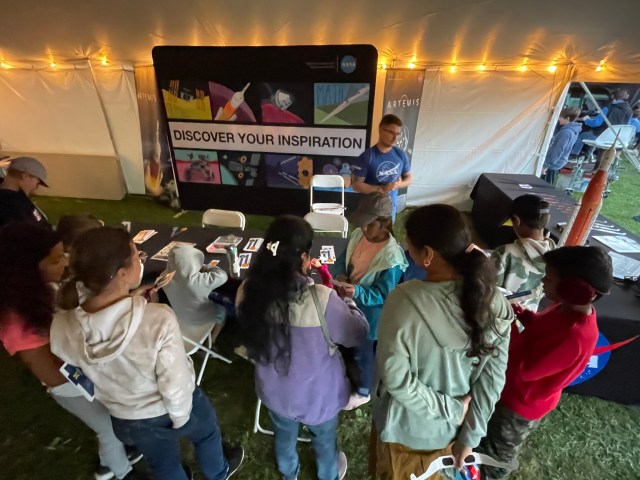 Matt Baeslack passes out kits for visitors to make a handheld solar eclipse viewer.
