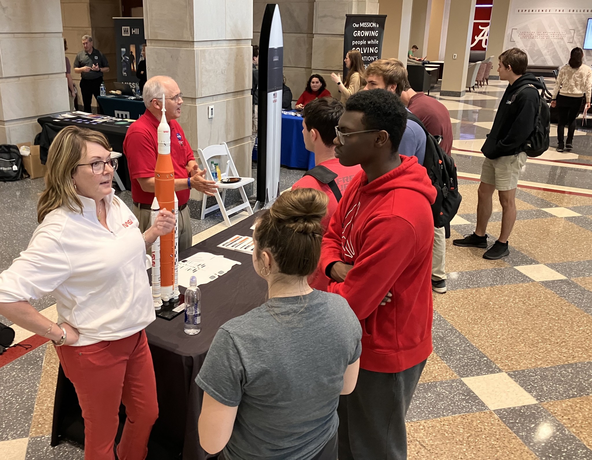 Holly Ellis, communication specialist, and Tim Smith, senior mission manager, both of the Technology Demonstration Missions Program, speak with students during Space Days at the University of Alabama on Nov. 15.