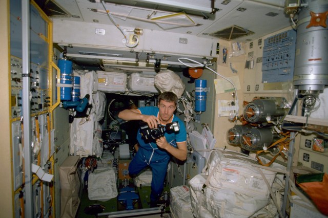 Cosmonaut Sergei K. Krikalev takes still pictures inside the Zvezda Service Module a few days after the arrival of the International Space Station's first crew. Krikalev, Expedition 1 flight engineer, represents the Russian Aviation and Space Agency. This is one of the first film images released from the Expedition 1 crew.