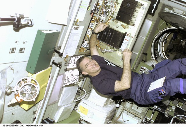 Astronaut James S. Voss, Expedition Two flight engineer, conducts electronics maintenance on the Zvezda Service Module aboard the International Space Station (ISS). This image was recorded with a digital still camera.(ISS). This image was recorded with a digital still camera.