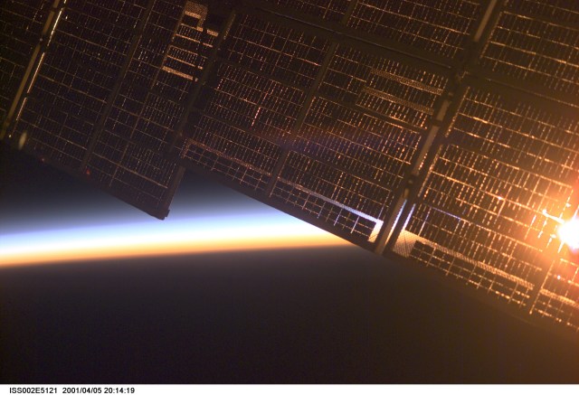 The solar panel supporting the Zvezda Service Module on the International Space Station (ISS) is backdropped against Earth's horizon at dawn. The image was made by one of the Expedition Two crew members using a digital still camera.