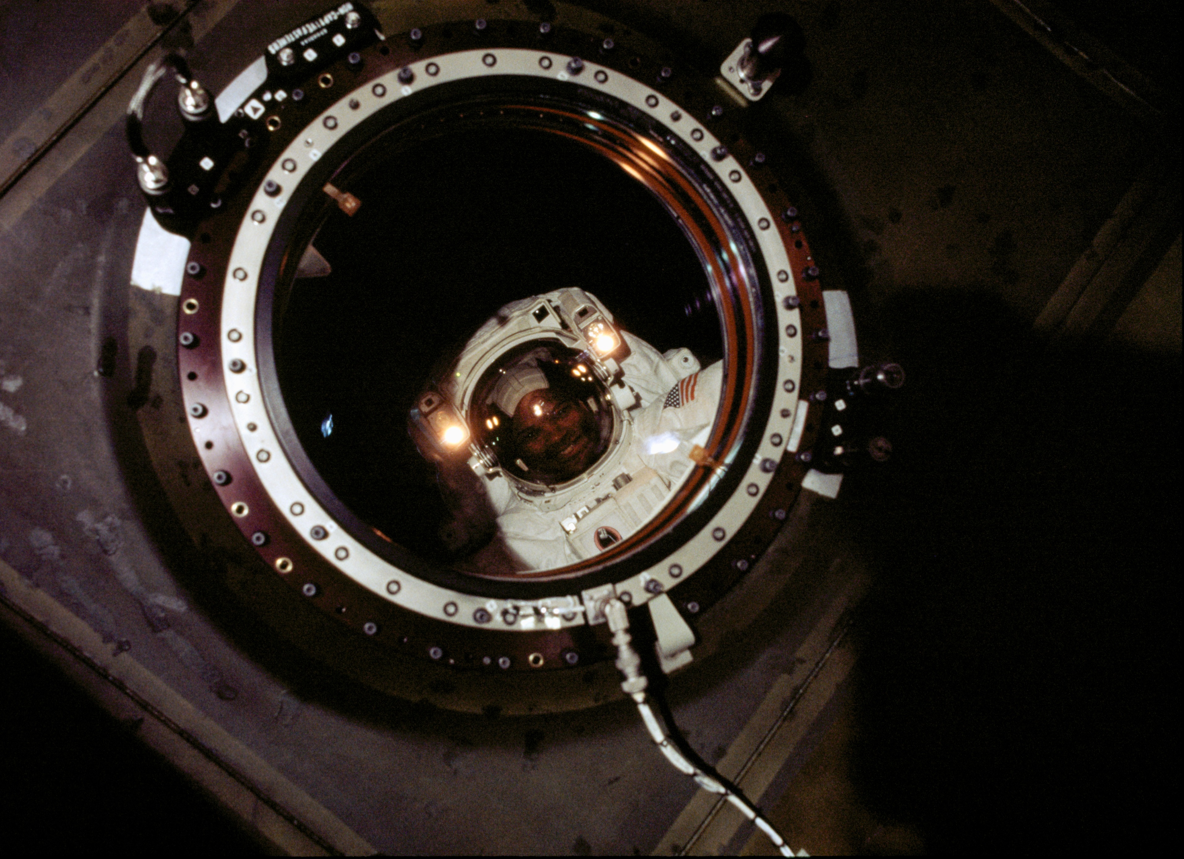 Astronaut Robert L. Curbeam, STS-98 mission specialist, was photographed by a member of the Expedition One crew in the newly installed Destiny laboratory during the second of three space walks. With all of the tasks planned for the second space walk completed, and still time available, the astronauts moved to tasks that had originally been planned for the third extravehicular activity (EVA) period on the flight. Ahead of schedule, they connected several computer and electrical cables between the docking port and the lab; unveiled the lab's large, high-quality window (through which this photo was taken) and attached an exterior shutter; and repositioned a movable foot platform they had taken inside Atlantis on the first spacewalk for a slight adjustment.