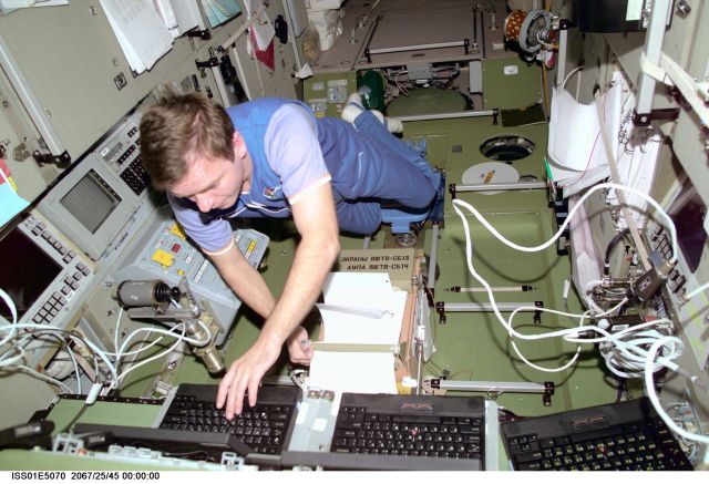Cosmonaut Yuri P. Gidzenko, Expedition 1 Soyuz commander, works with computers in the Zvezda Service Module aboard the Earth-orbiting International Space Station (ISS). The picture was taken with a digital still camera.