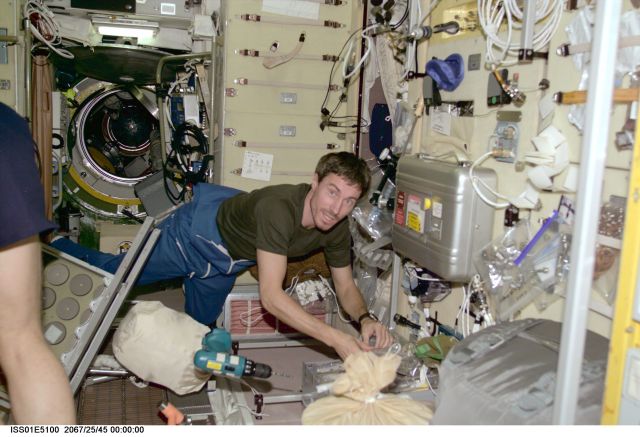 Cosmonaut Sergei K. Krikalev, Expedition 1 flight engineer, retrieves some tools on the International Space Station's Zvezda Service Module.