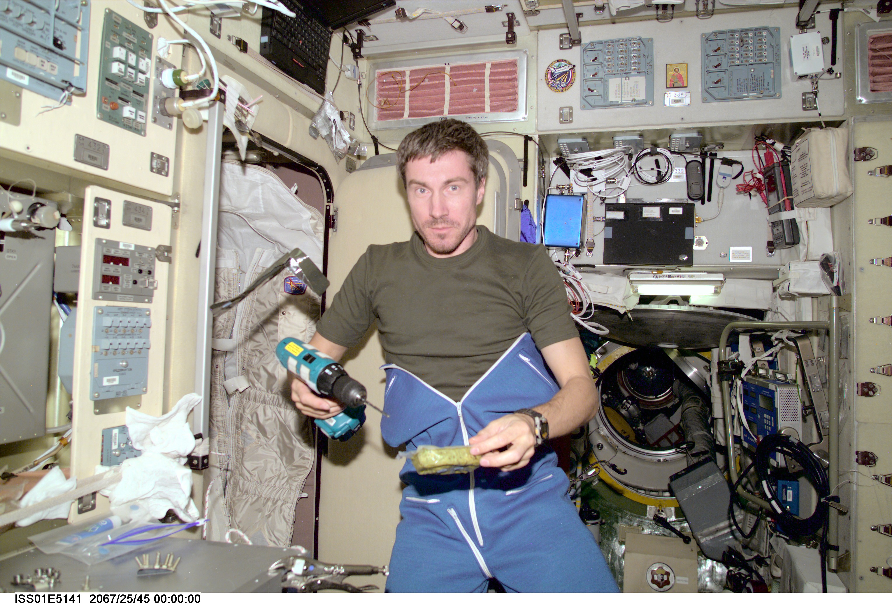 Cosmonaut Sergei K. Krikalev, Expedition One flight engineer, combines work and eating in the Zvezda service module aboard the Earth-orbiting International Space Station (ISS). The picture was recorded with a digital still camera.