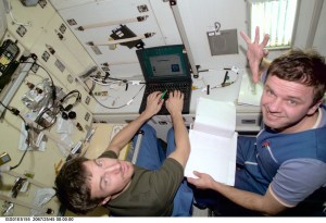 Cosmonauts Sergei K. Krikalev (left), Expedition 1 flight engineer, and Yuri P. Gidzenko, Soyuz commander, input data into a laptop computer in the Zvezda Service Module aboard the Earth-orbiting International Space Station (ISS).