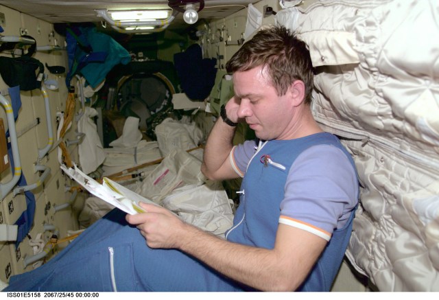Cosmonaut Yuri P. Gidzenko, Expedition One Soyuz commander, looks over an ISS document on a clipboard in the Zarya Functional Cargo Block (FGB). The image was taken with a digital still camera and down linked from the station to ground controllers in Houston.