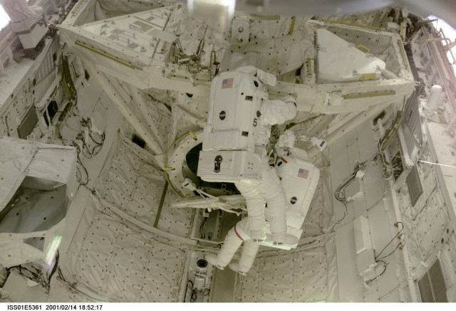 Astronauts Thomas D. Jones (red stripes on suit) and Robert L. Curbeam, STS-98 mission specialists, are pictured in the cargo bay of the Space Shuttle Atlantis during their third space walk, as photographed with a digital still camera from the International Space Station's new Destiny laboratory.
