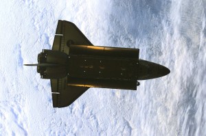 This partially silhouetted nadir image of the Space Shuttle Atlantis was photographed by the three-man Expedition One crew aboard the International Space Station (ISS) shortly after the shuttle and the outpost unlinked following several days of joint operations of the two crews. The scene, backdropped against a mass of white clouds on Earth, was recorded with a digital still camera.