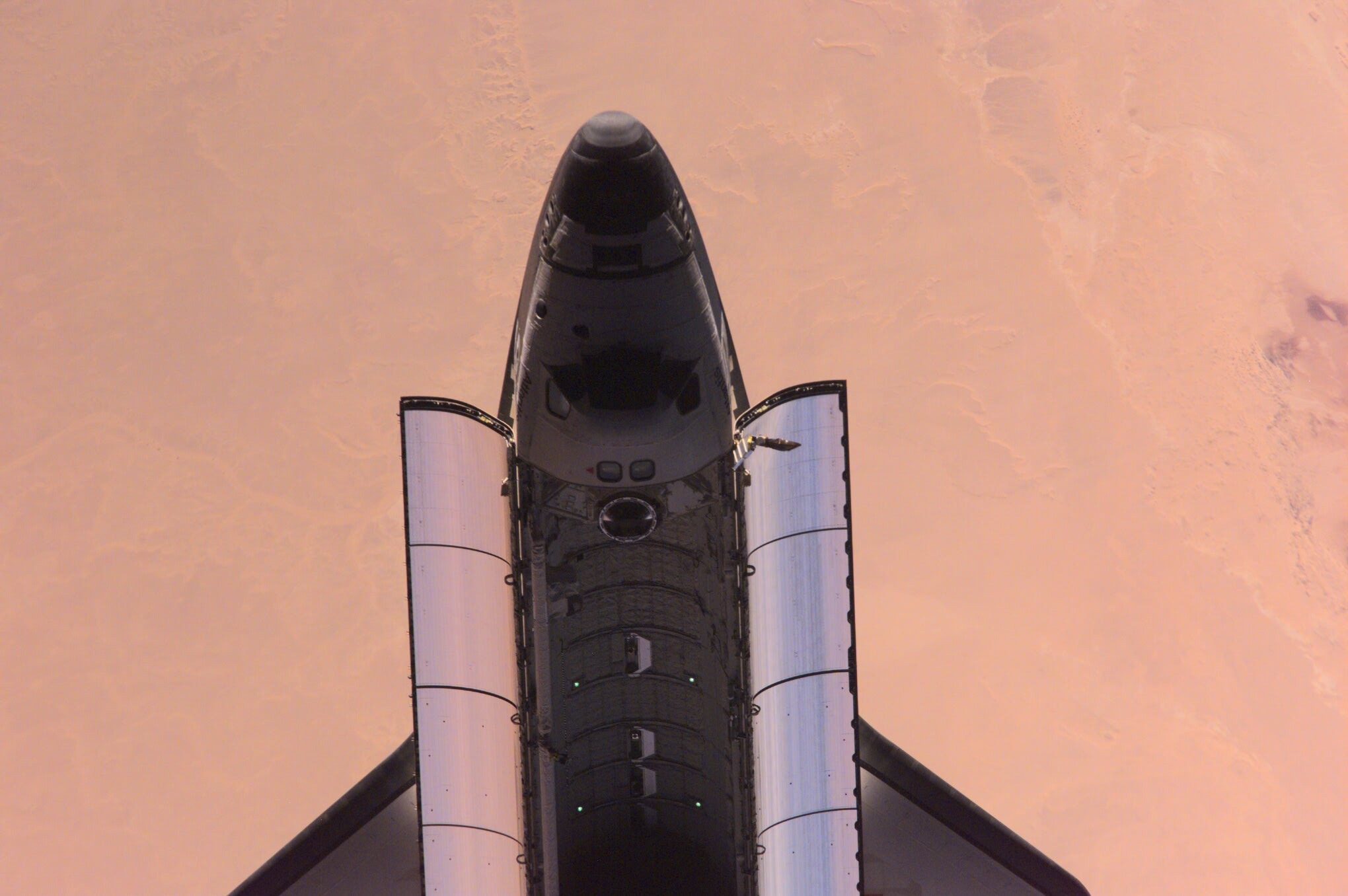 This nadir image of the Space Shuttle Atlantis backdropped over a desert was photographed by the three-man Expedition One crew aboard the International Space Station (ISS) shortly after the shuttle and the outpost unlinked following several days of joint operations of the two crews. The scene was recorded with a digital still camera.