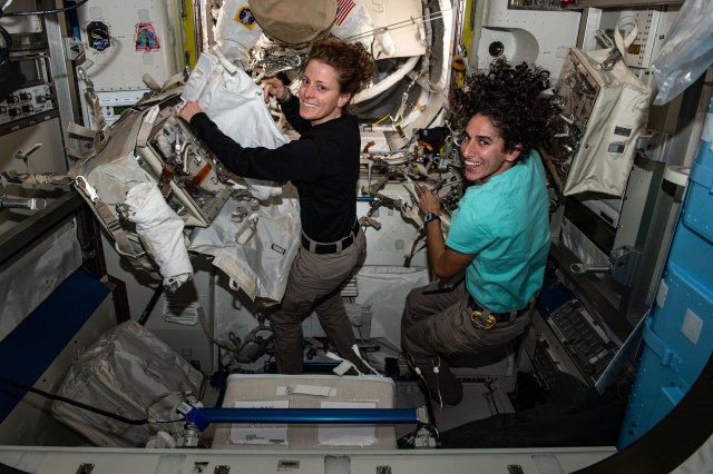 Expedition 70 Flight Engineers (from left) Loral O'Hara and Jasmin Moghbeli, both NASA astronauts, configure spacewalking tools inside the International Space Station's Quest airlock.