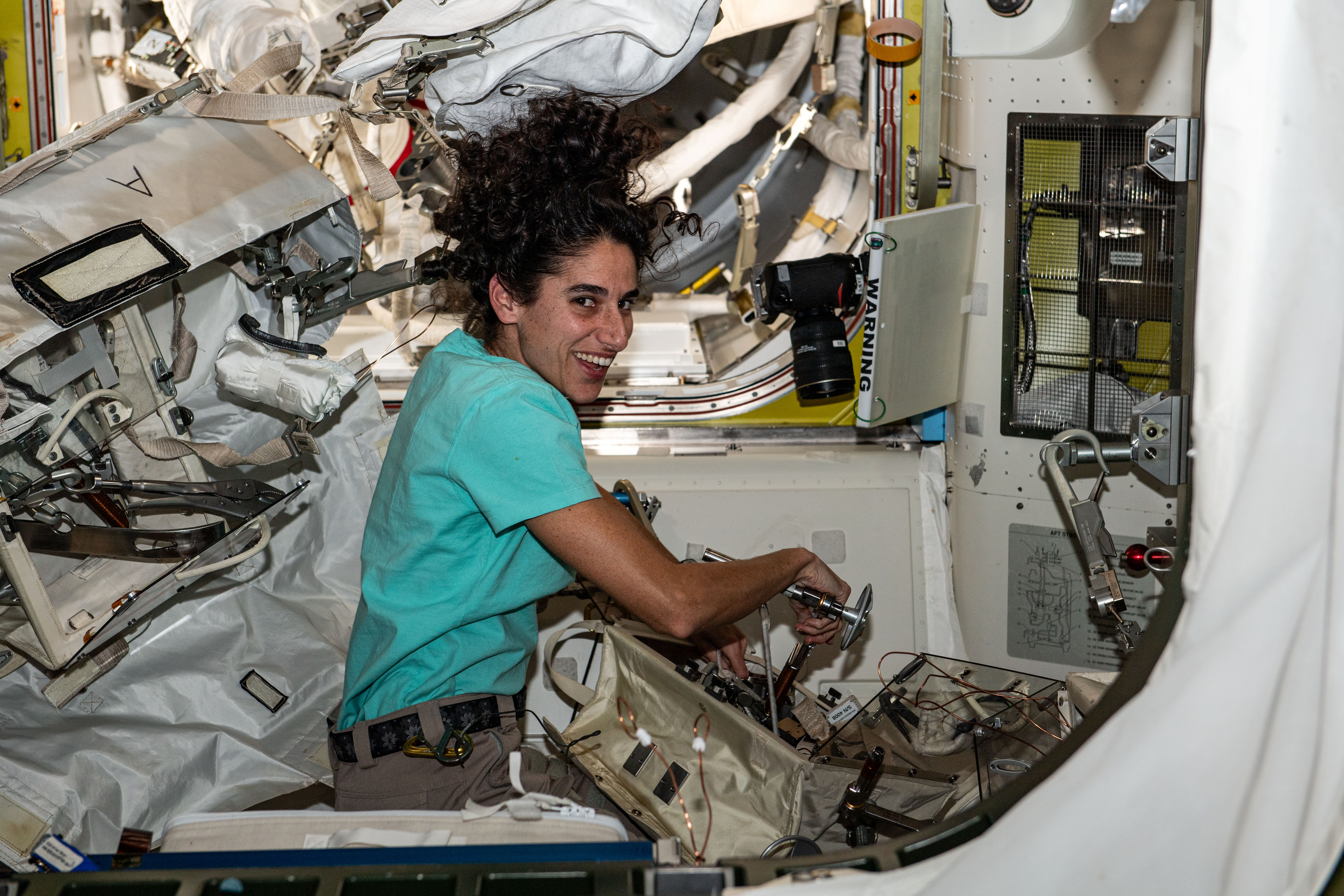 NASA astronaut and Expedition 70 Flight Engineer Jasmin Moghbeli configures spacewalking tools inside the International Space Station's Quest airlock.