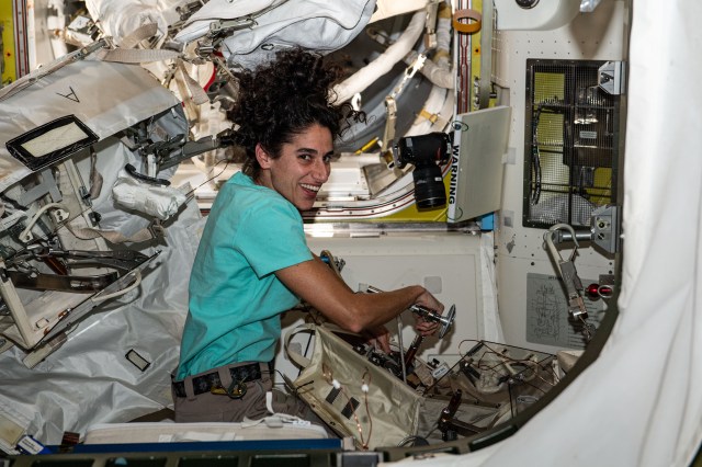 NASA astronaut and Expedition 70 Flight Engineer Jasmin Moghbeli configures spacewalking tools inside the International Space Station's Quest airlock.