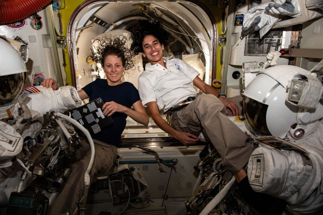 Expedition 70 Flight Engineers (from left) Loral O'Hara and Jasmin Moghbeli, both NASA astronauts, pose for a portrait while installing helmet lights on spacesuits and checking the functionality of their spacesuit's components.
