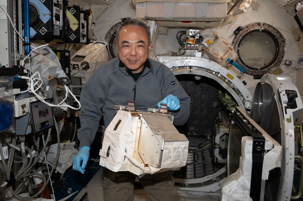 JAXA (Japan Aerospace Exploration Agency) astronaut and Expedition 70 Flight Engineer Satoshi Furukawa removes hardware from inside the Kibo laboratory module's airlock.
