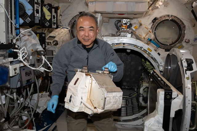 JAXA (Japan Aerospace Exploration Agency) astronaut and Expedition 70 Flight Engineer Satoshi Furukawa removes hardware from inside the Kibo laboratory module's airlock.