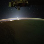 The sun's first rays begin illuminating Earth's atmosphere in this photograph from the International Space Station as it orbited 262 miles above the Pacific Ocean off the coast of California.
