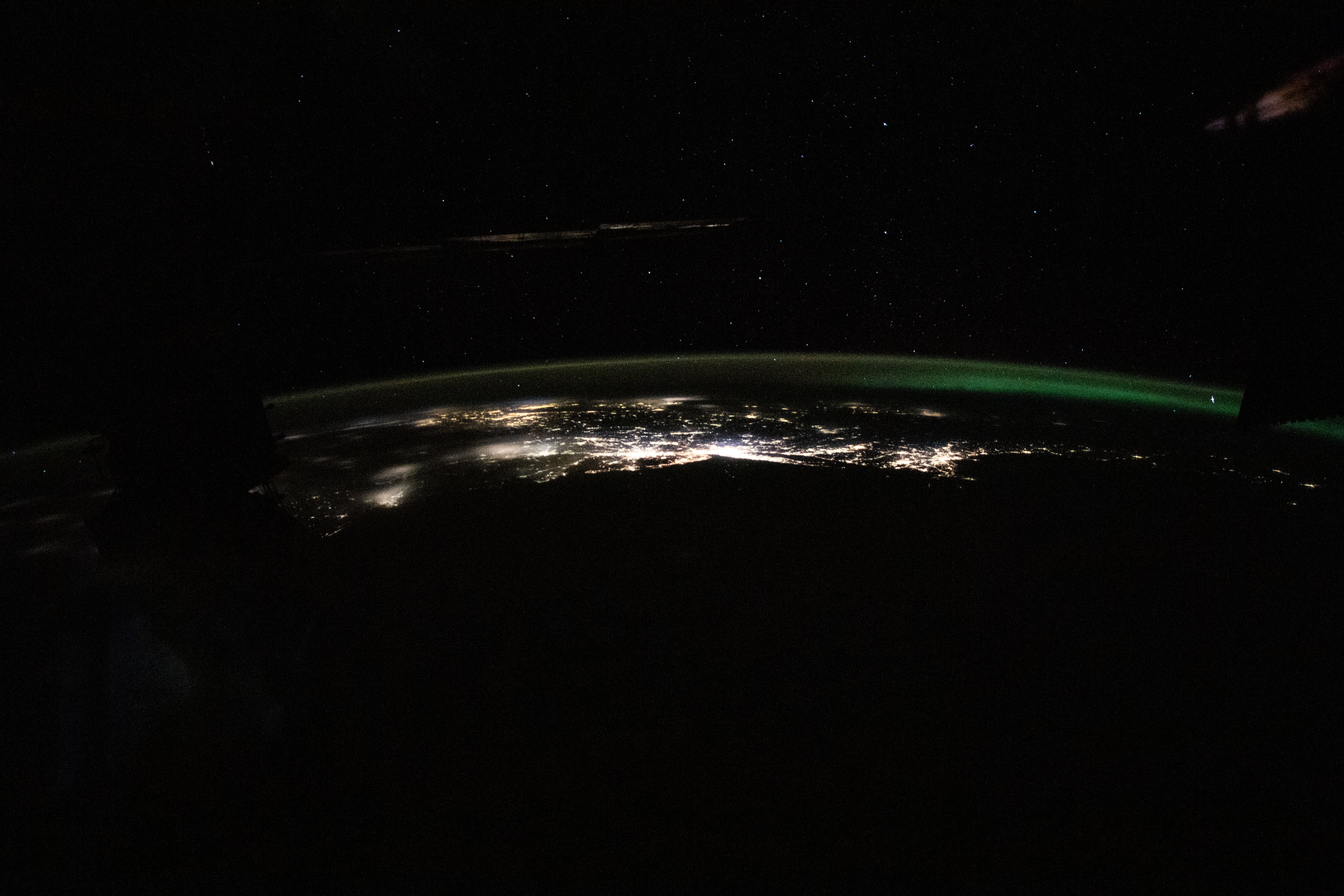 The photograph from the International Space Station looks back toward the northeast Atlantic coast of the United States revealing the city lights (from left) of Norfolk, Virginia, to Boston, Massachusetts. At far right, an aurora in northern Canada crowns the Earth's horizon.
