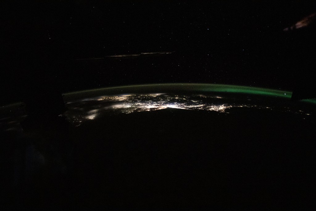 The photograph from the International Space Station looks back toward the northeast Atlantic coast of the United States revealing the city lights (from left) of Norfolk, Virginia, to Boston, Massachusetts. At far right, an aurora in northern Canada crowns the Earth's horizon.