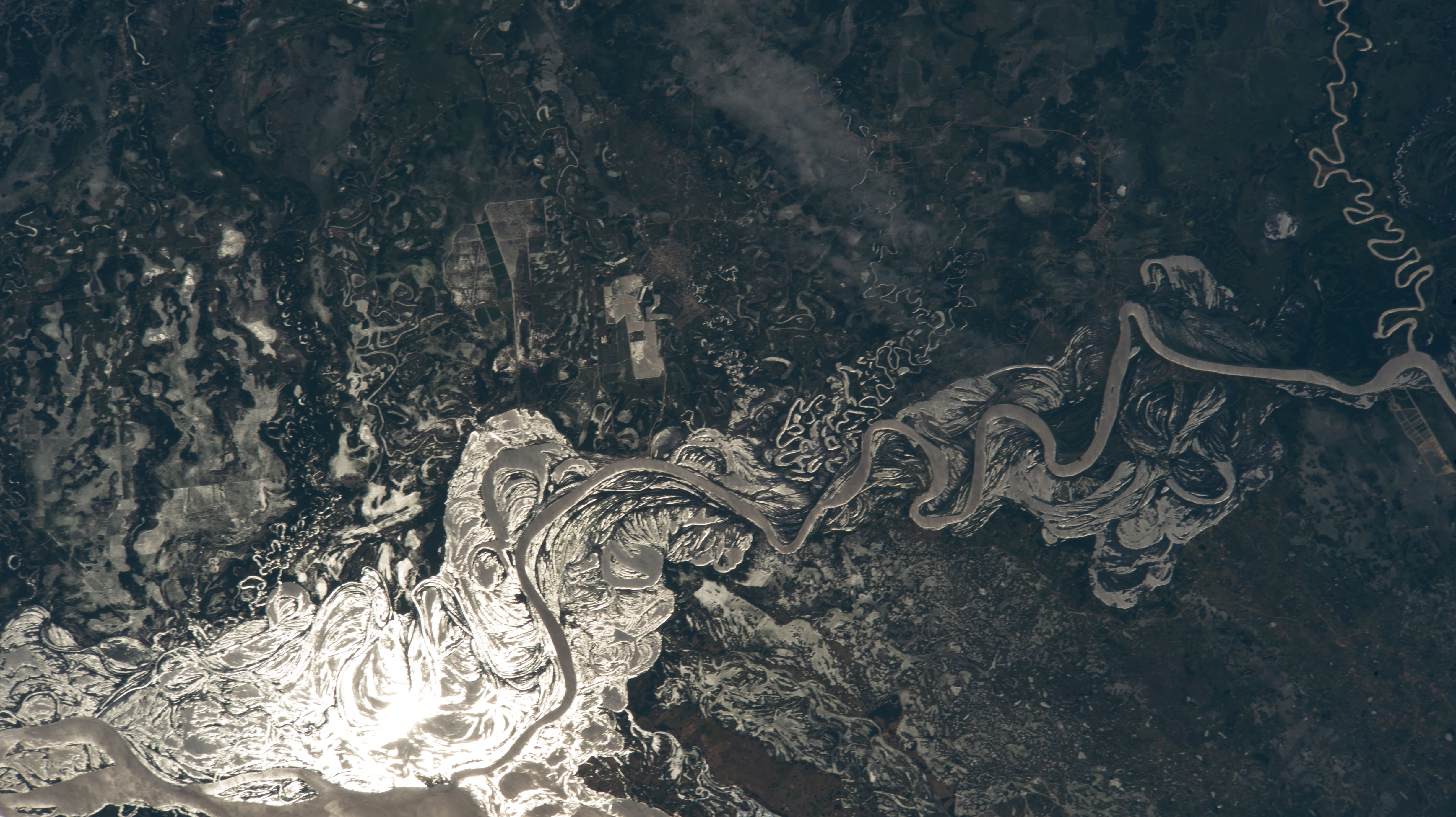 The sun's glint beams off the Paraguay River which separates a portion of the South American nations of Argentina and Paraguay in this photograph from the International Space Station as it orbited 265 miles above.