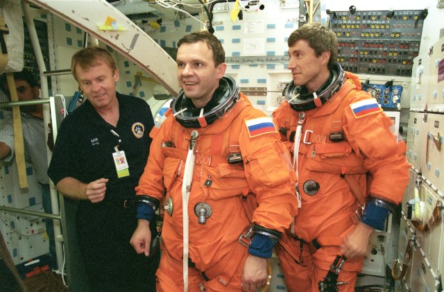 wo cosmonauts assigned to ISS Expedition 1 participate in shuttle descent and egress training on the mid deck of the Crew Compartment Trainer (CCT) at the Johnson Space Center's systems integration facility. Pictured in the burnt-orange pressure suits are Yuri Gidzenko (center), Soyuz commander; and Sergei Krikalev, flight engineer. At left is astronaut Andrew S.W. Thomas who assisted the crew members in this training session. Gidzenko, Krikalev and astronaut William Shepherd (not in picture), mission commander, were training for descent procedures, both routine and contingency measures, in the session. Their stay aboard ISS will conclude when they return to Earth aboard a shuttle.