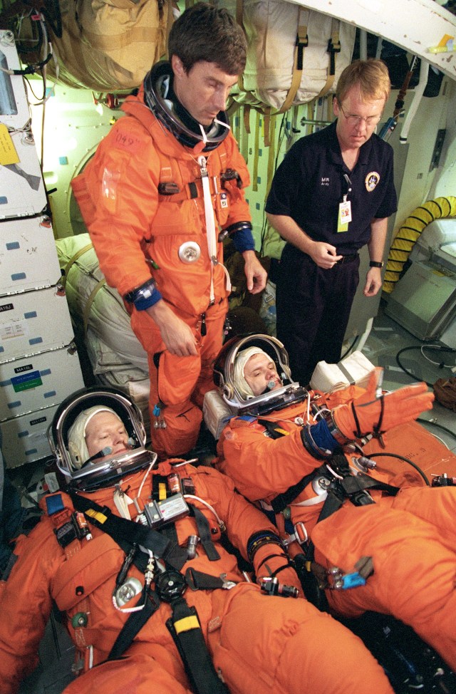 Astronaut William Shepherd (bottom left), Expedition 1 mission commander, and cosmonaut Yuri Gidzenko, Soyuz commander, lie on couches on the mid deck of a Johnson Space Center trainer during a rehearsal of shuttle descent. Cosmonaut Sergei Krikalev, the third Expedition 1 crew member, is not yet positioned on his couch. He will serve as flight engineer for the crew. Next to him is astronaut Andrew S.W. Thomas, who assisted in the shuttle-descent simulation in one of the Johnson Space Center's Crew Compartment Trainers (CCT).