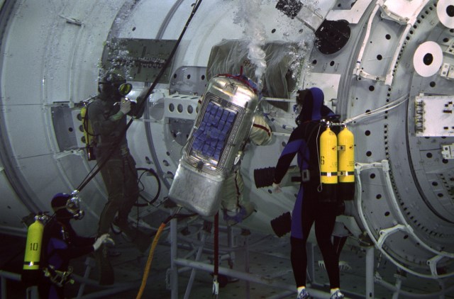 Astronaut William Shepherd, ISS Expedition 1 commander, rehearses an extravehicular activity (EVA) with a full scale training model of the Zvezda Service Module in the Hydrolab facility at the Gagarin Cosmonaut Training Center in Russia. SCUBA-equipped divers assist in the spacewalk rehearsal.