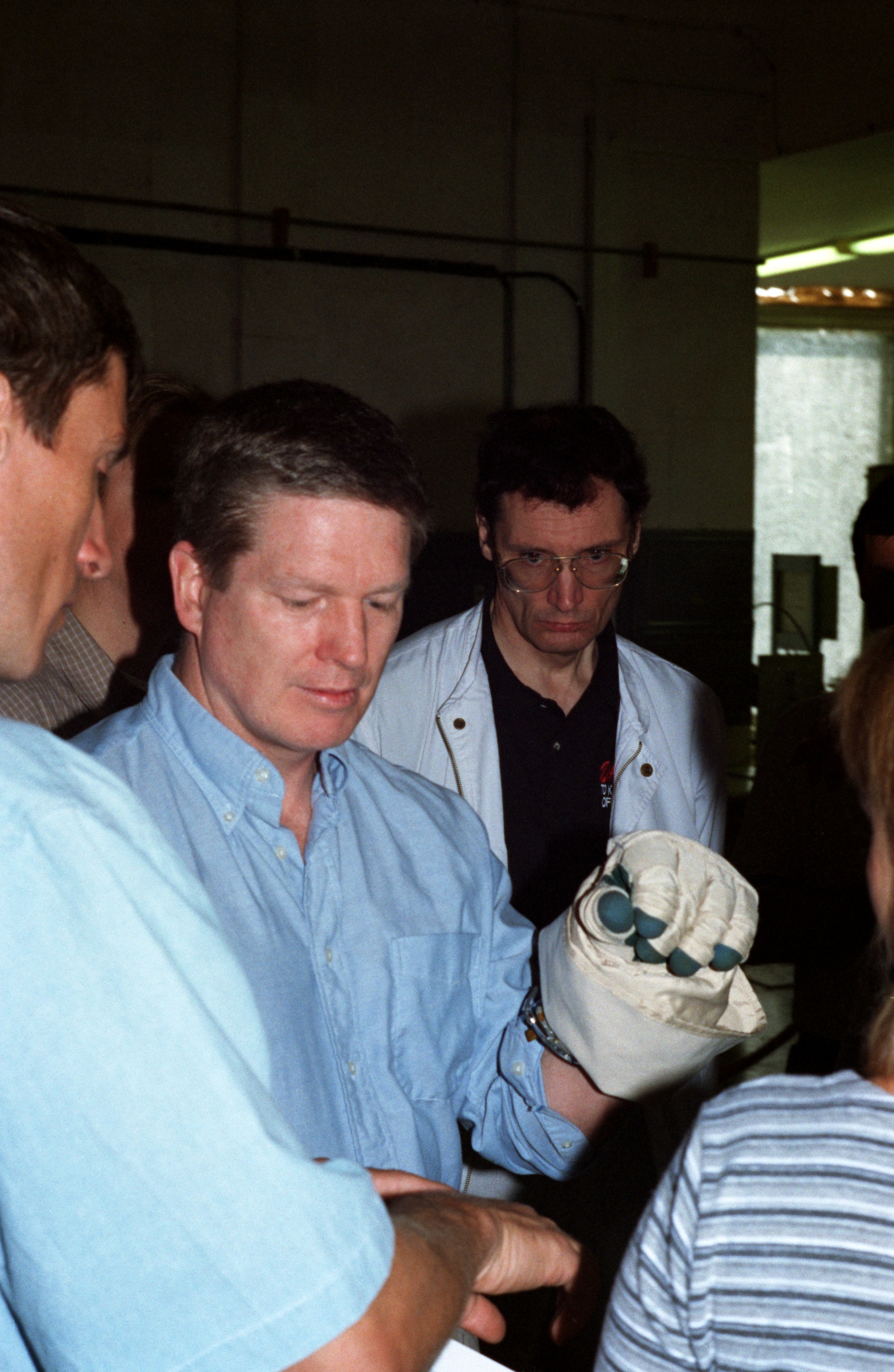 Astronaut William Shepherd, mission commander for ISS Expedition 1, checks out a glove prior to participating in an underwater spacewalk simulation in the Hydrolab facility at the Gagarin Cosmonaut Training Center in Russia. Cosmonaut Sergei Krikalev, flight engineer, is at left edge of frame.