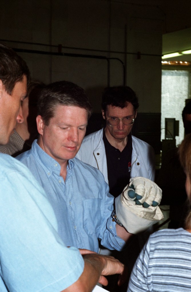 Astronaut William Shepherd, mission commander for ISS Expedition 1, checks out a glove prior to participating in an underwater spacewalk simulation in the Hydrolab facility at the Gagarin Cosmonaut Training Center in Russia. Cosmonaut Sergei Krikalev, flight engineer, is at left edge of frame.